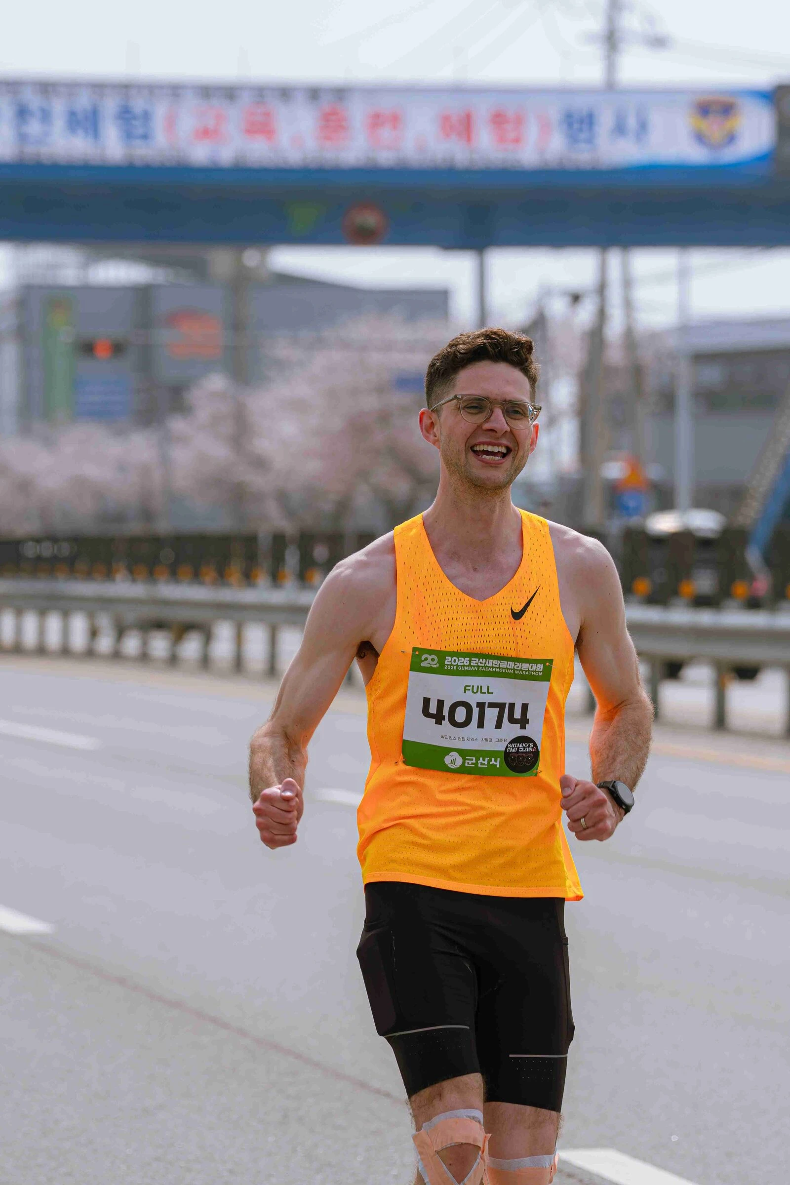 Quintin running a road race in Korea, fist raised on the course.